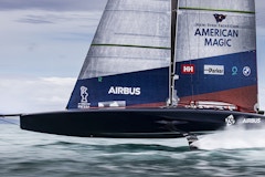 America's Cup racing yacht American Dream flying over the water.