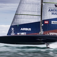America's Cup racing yacht American Dream flying over the water.