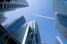 contrail amidst tall buildings